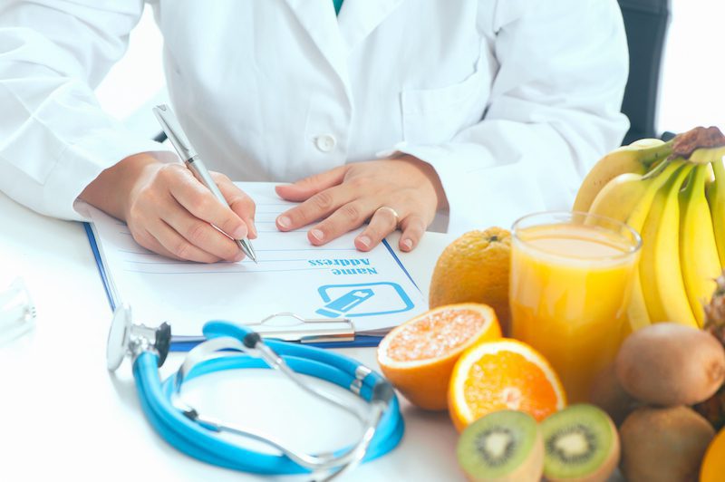 nutrionist writing with healthy food around