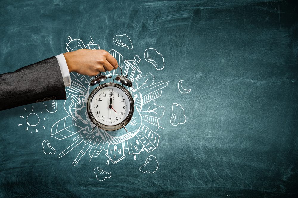 Time management | Hand holding an alarm clock