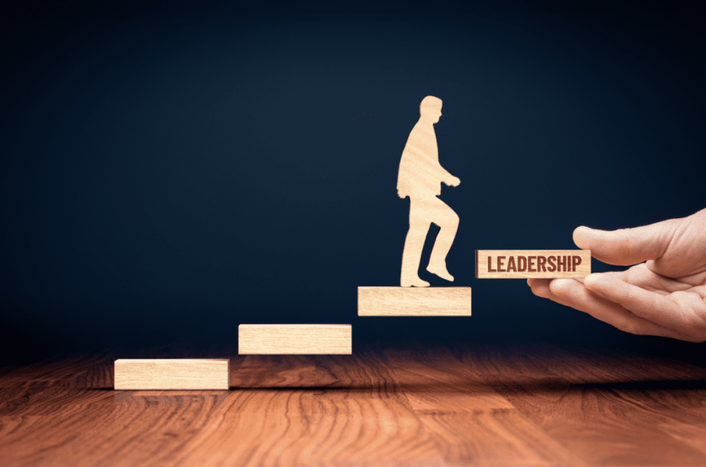 Best leadership books | wooden blocks with a person walking up. One has "leadership" written into the side. 