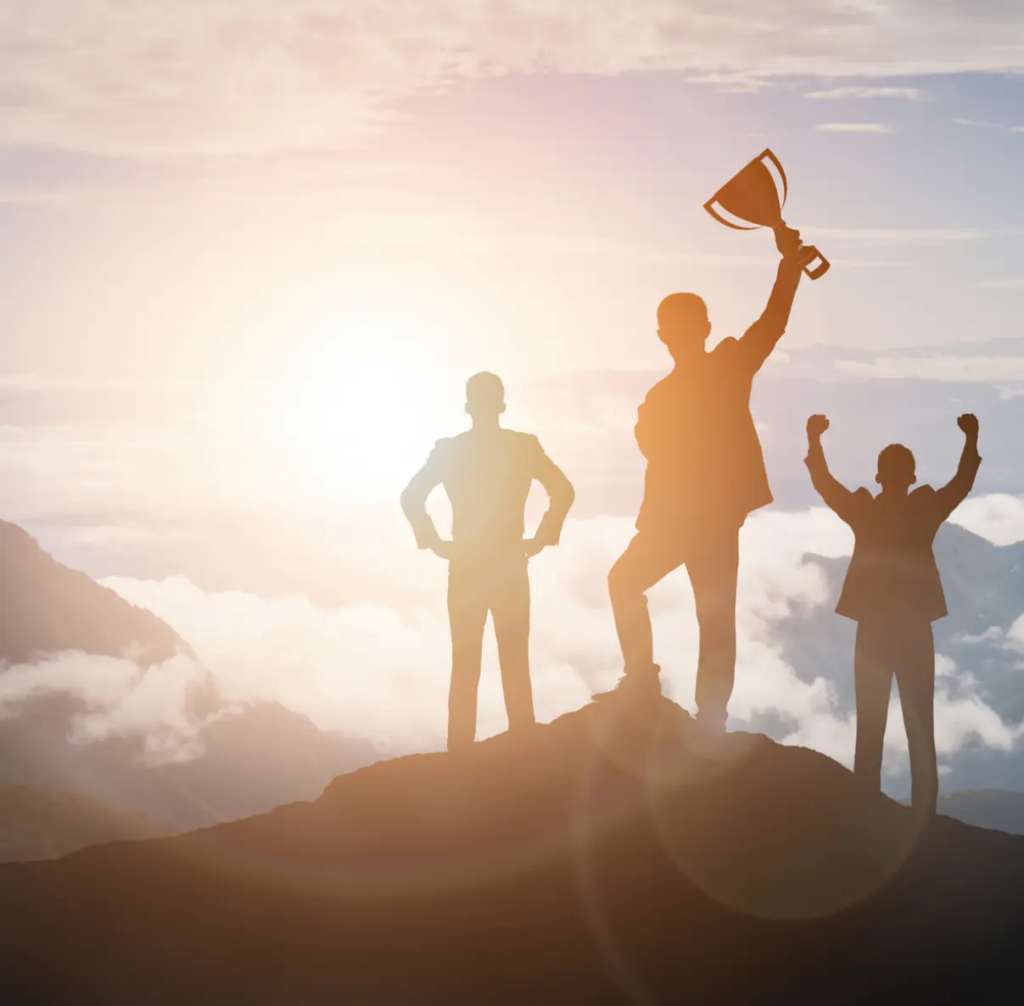 Business coaching services | Group of people on top of a mountain holding a trophy.