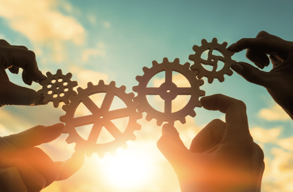 Small business owner | People holding up cogs and gears that fit together.