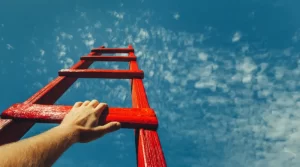 Uckfield Businesses | Ladder stretching into the sky with a hand climbing up.