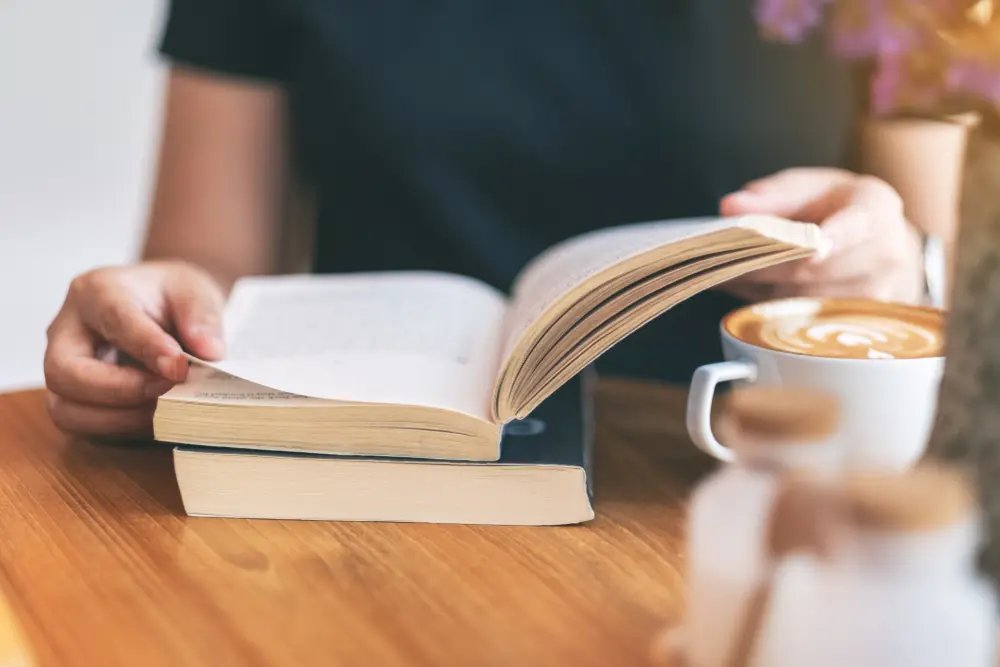 woman reading business development books with coffee