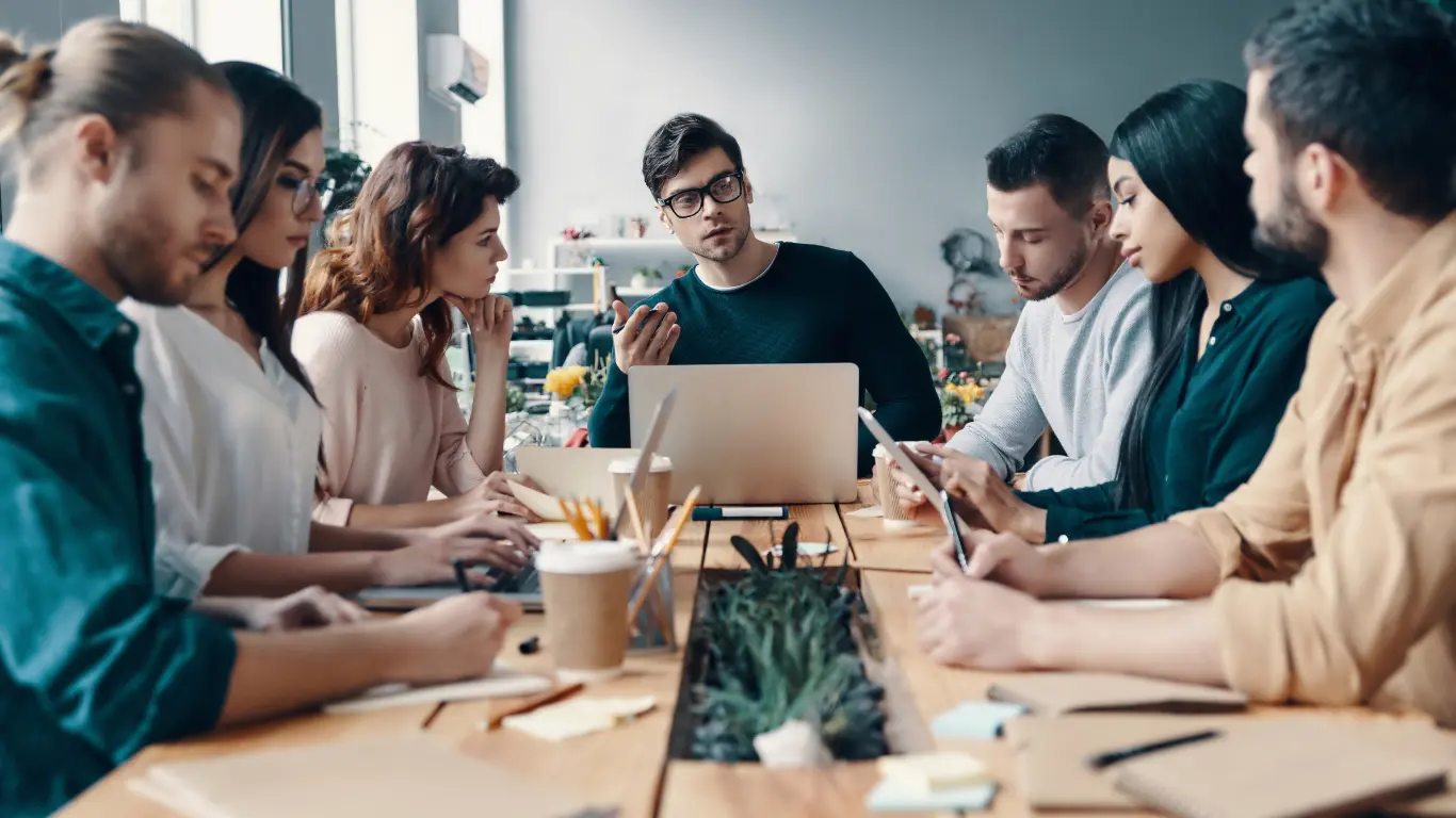 Leadership development in business - Group of people sitting round a table