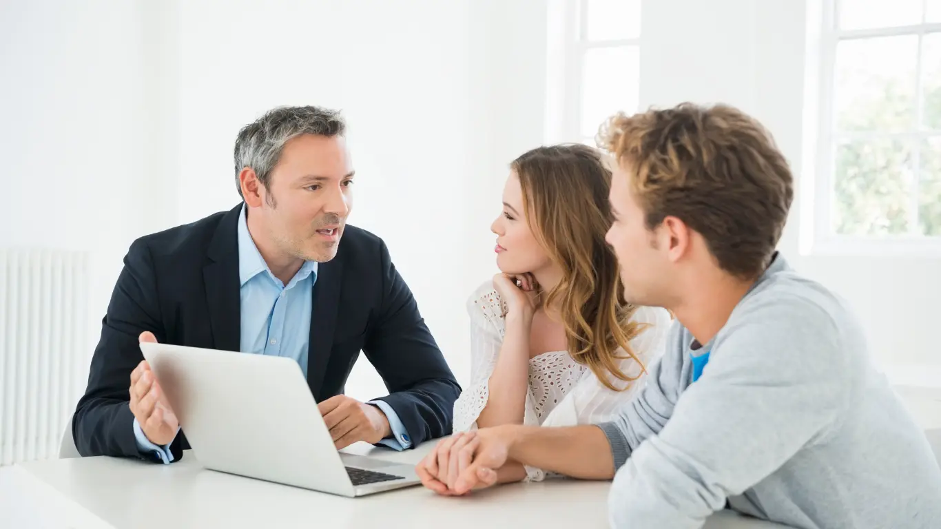 business coach for financial advisors with a male and female at a desk looking at a laptop